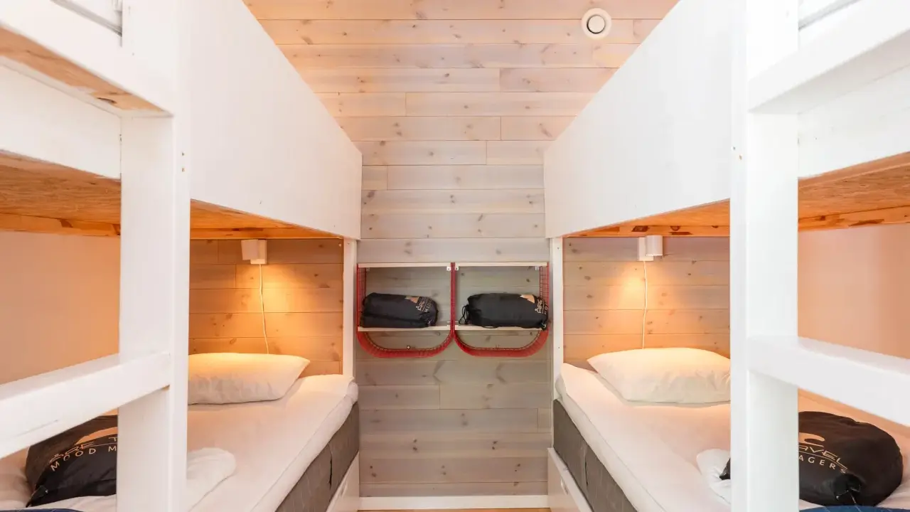 Två våningssängar i en mysig stuga, perfekt för camping i Åre. Sängkläder och sovsäckar redo för äventyr.