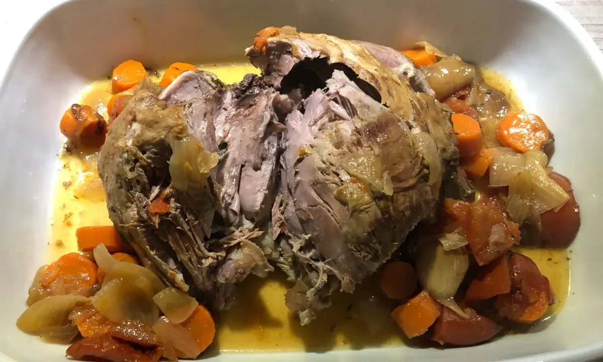 Gigot de 7 heures, tendre et effiloché, baignant dans son jus avec carottes et oignons. Faut il couvrir le gigot de 7 heures ? Oui, pour une cuisson parfaite !