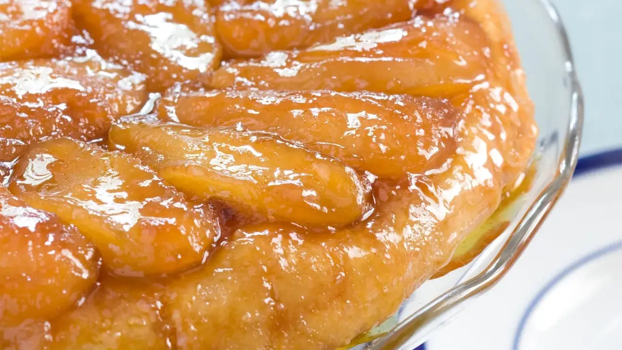 Une délicieuse tarte tatin aux pommes caramélisées, servie dans un plat en verre.