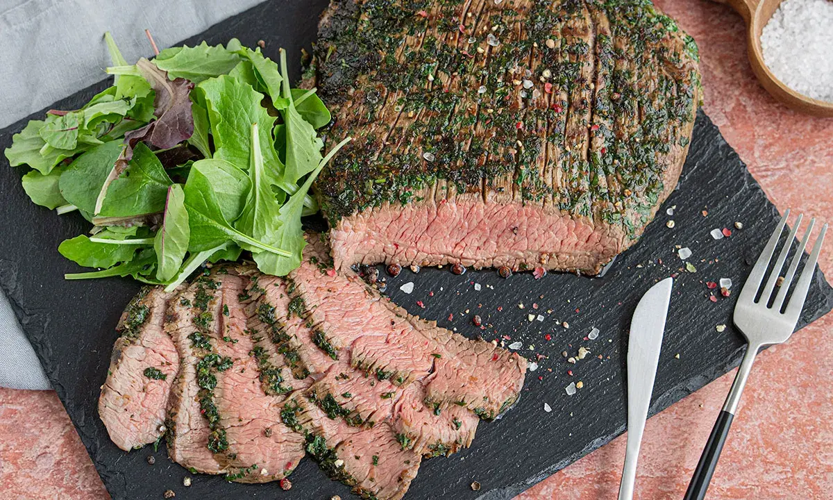 Perfekt mariniertes Flanksteak, aufgeschnitten und mit frischem Salat serviert. Ein Genuss für jeden Fleischliebhaber.