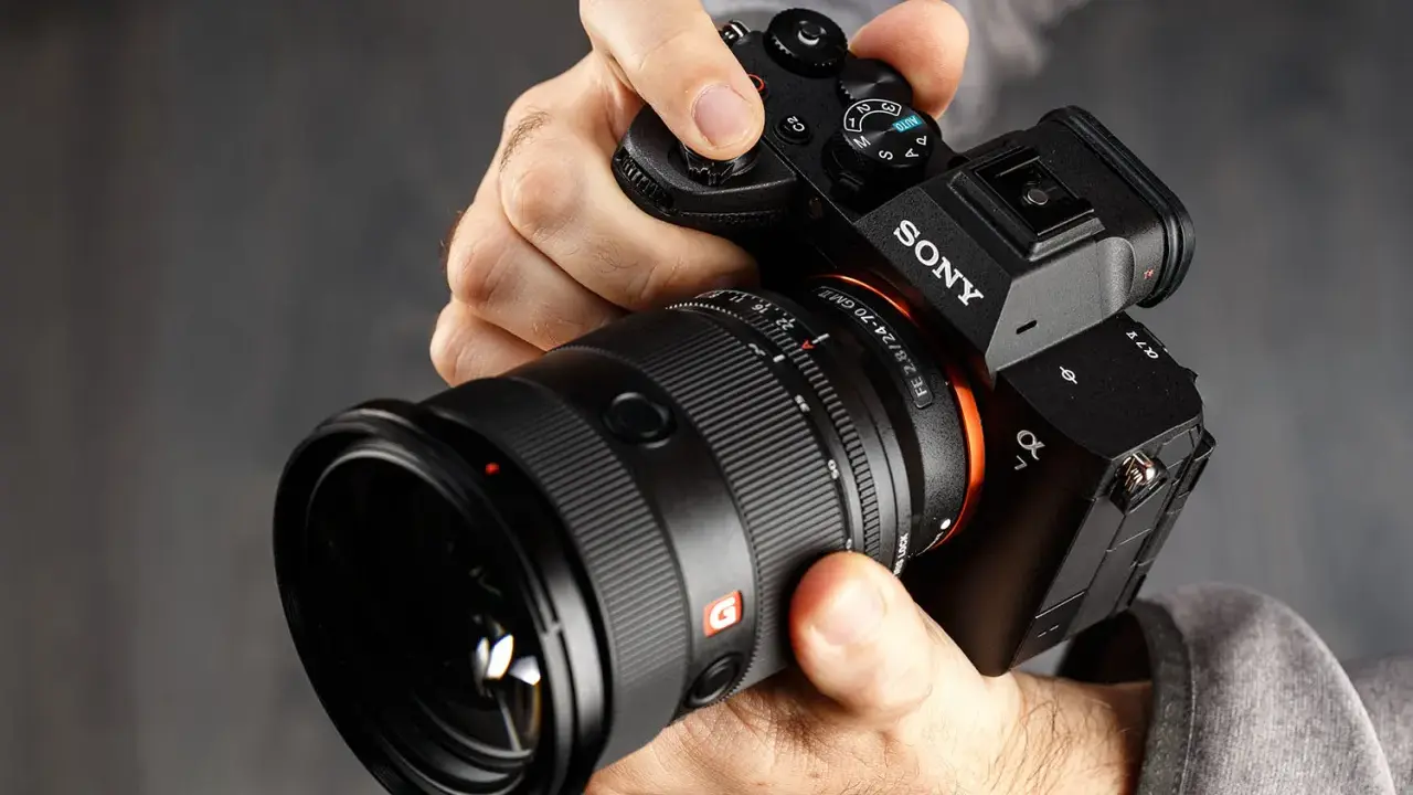 Mani che impugnano una Sony A7, obiettivo GM 2.8/24-70. Dettagli per la recensione.