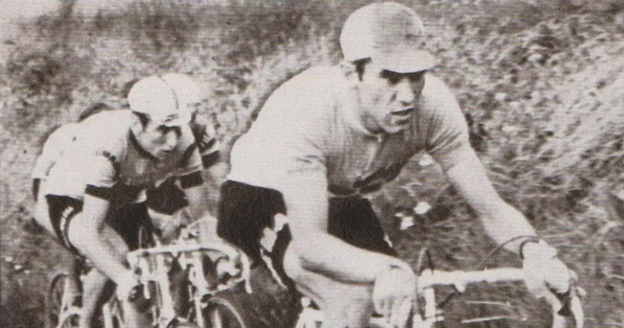 Dwóch kolarzy w akcji. Na pierwszym planie widać zawodnika w czarnych spodenkach i jasnej koszulce, zdeterminowanego jak zawsze Eddy Merckx.
