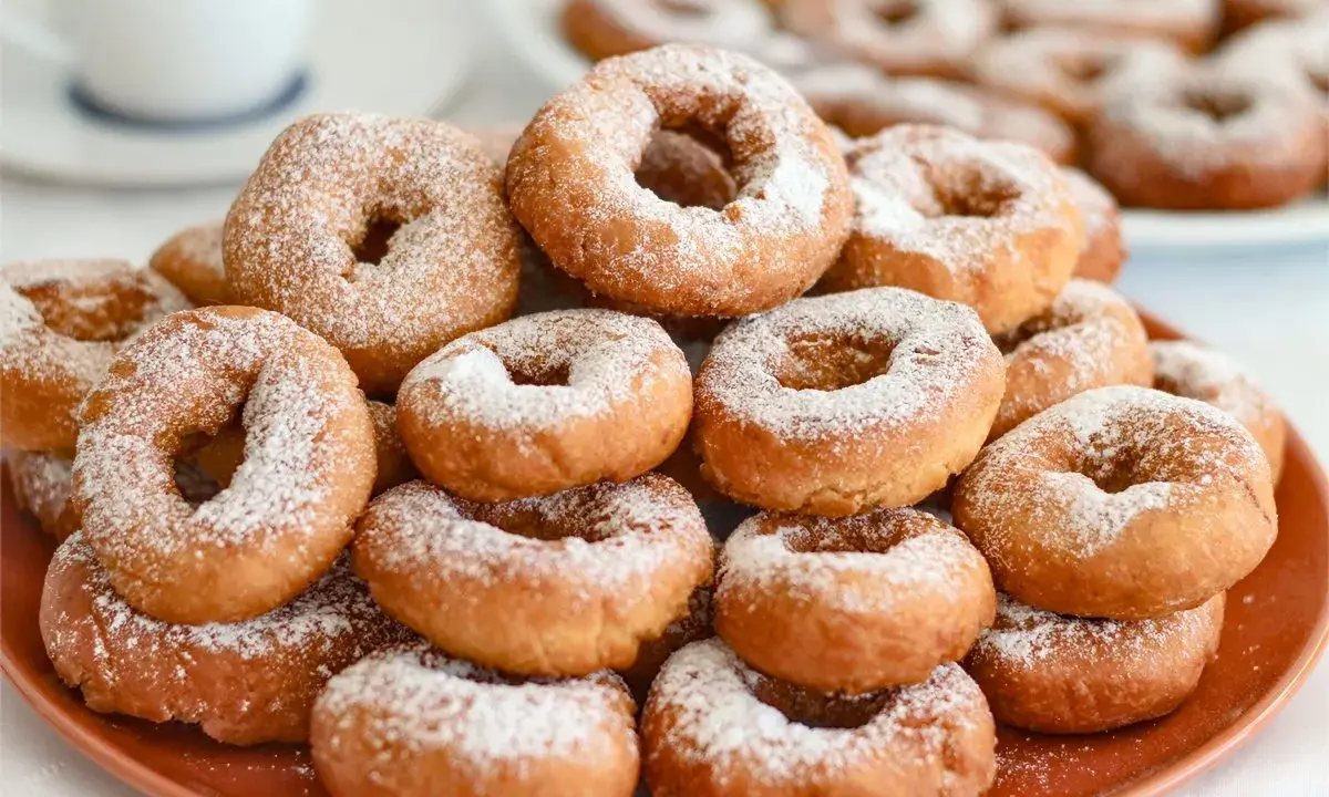 Montón de rosquillas caseras esponjosas espolvoreadas con azúcar glas.