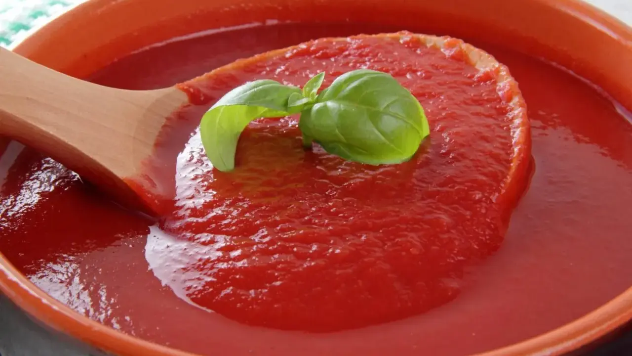 Gęsty, domowy ketchup w ceramicznej misie, nabierany drewnianą łyżką. Idealny przepis na ketchup z bazylią.