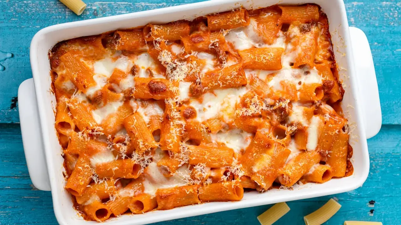 Un invitante piatto di pasta al forno con sugo rosso e formaggio filante, pronto per essere gustato.