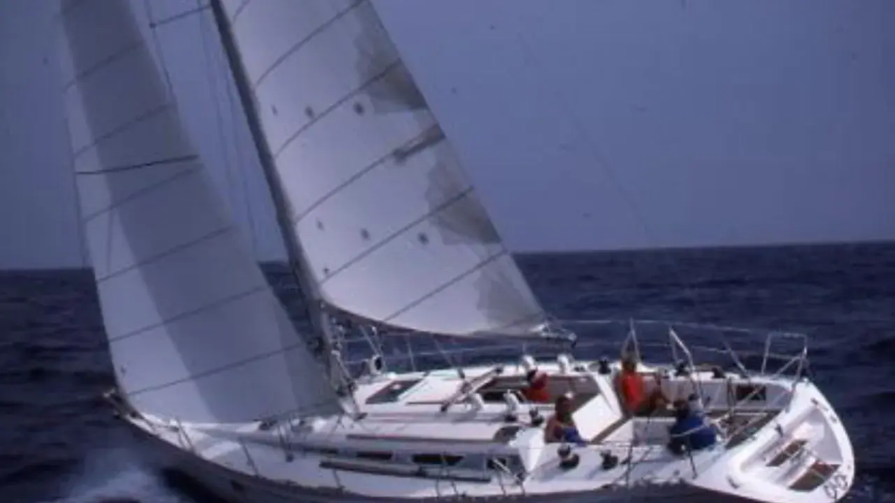 Un voilier navigue sur une mer agitée, ses voiles gonflées par le vent. Un rêve au soleil, 28 avis sur cette belle journée.