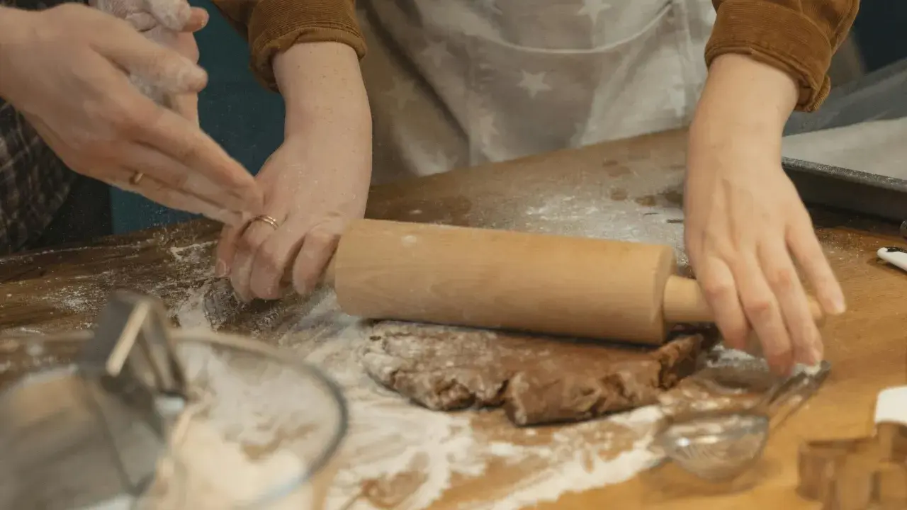 Mains farinées étalant une pâte à biscuits. Une question se pose : par quoi remplacer la farine de sarrasin pour une recette sans gluten ?