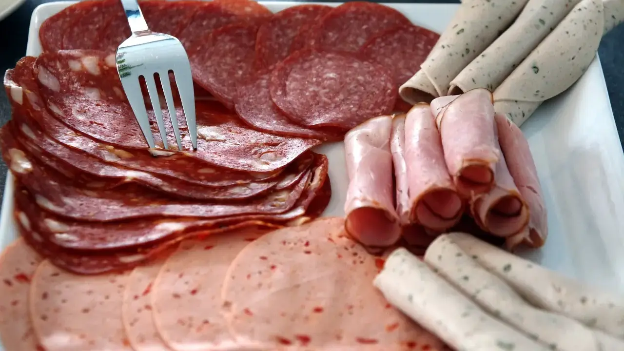 Talerz z wędlinami: salami, szynka, kiełbasa. Jak przechowywać wędlinę w lodówce? Najlepiej w szczelnym pojemniku.