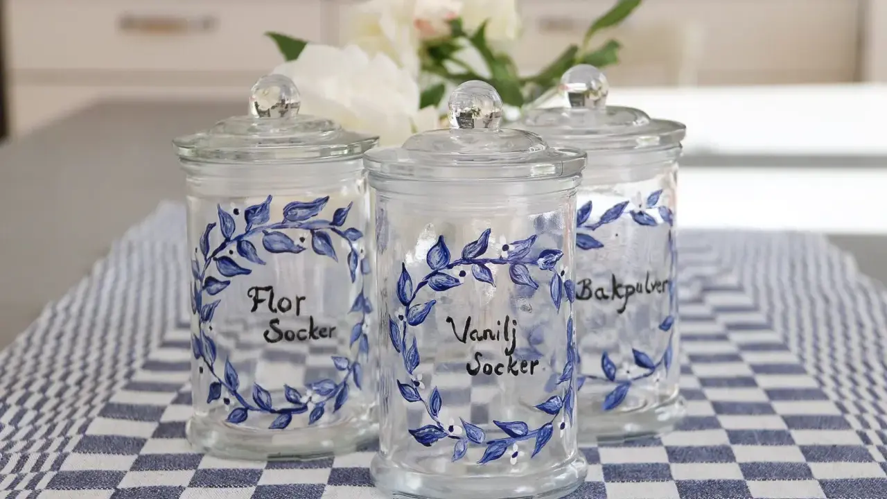 Tre vackra glasburkar med blå blommotiv, perfekta för att måla på glasburkar och förvara socker eller bakpulver.