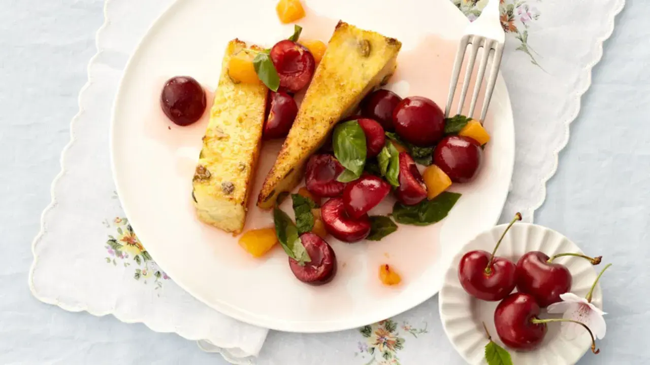 Zwei Scheiben süßer Auflauf mit frischen Kirschen und Aprikosenstücken. Ein köstliches Dessert, das Lust auf mehr Kirschen Rezepte macht.