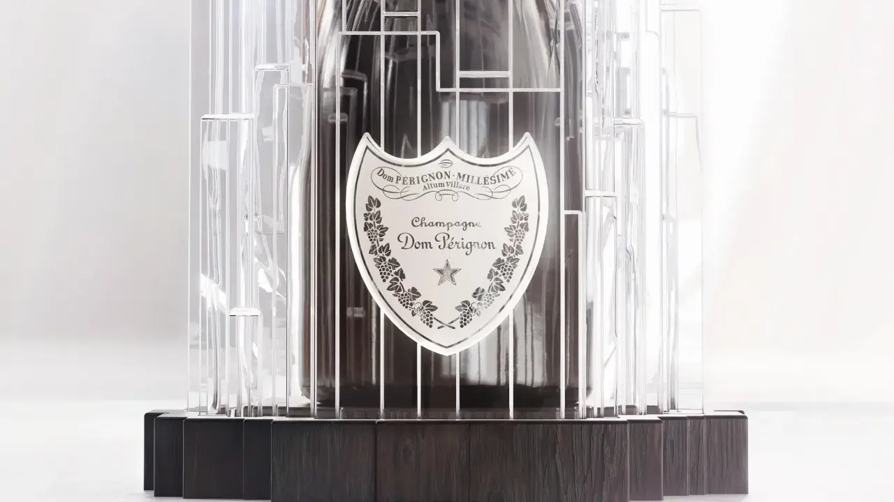 Dom Pérignon Vintage 2012 in einer modernen, transparenten Hülle mit dunklem Holzsockel.