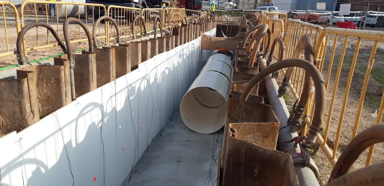 Instalación de tuberías en ntp zanjas, con soportes metálicos y mangueras de bombeo.