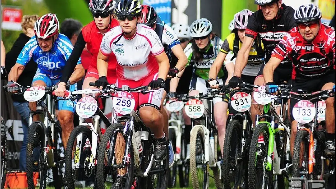 Zawodnicy w kaskach i strojach kolarskich startują w wyścigu mtb bike maraton.