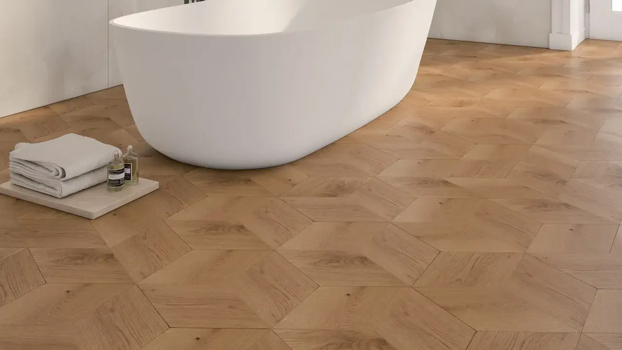 Bagno moderno con vasca freestanding e pavimento in parquet geometrico. Idee bagno con parquet per un tocco di calore e design.