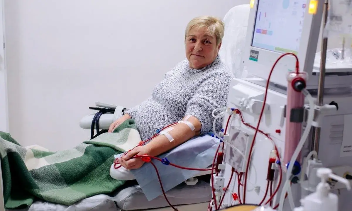 Kobieta podłączona do dializy przez cewnik dializacyjny. Maszyna do dializy monitoruje jej stan.