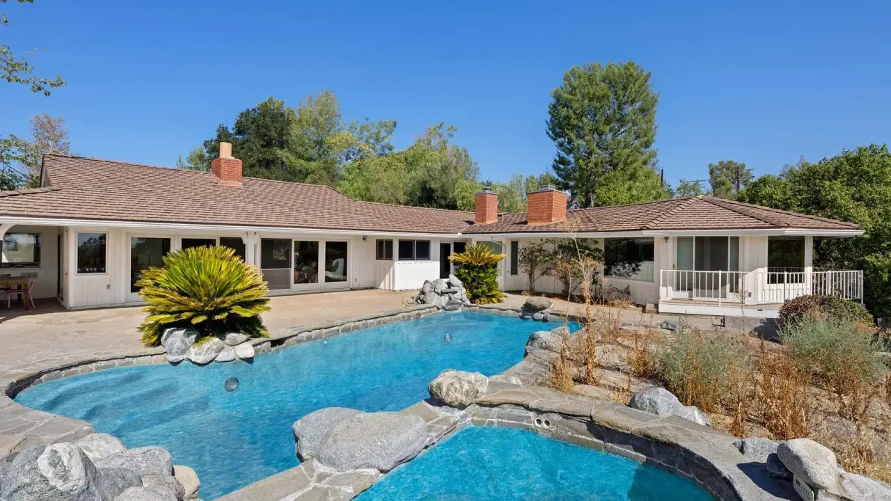 La piscina e il giardino di una casa che ricorda lo stile del **Kim Kardashian house**, con un'architettura moderna e un'area esterna rilassante.