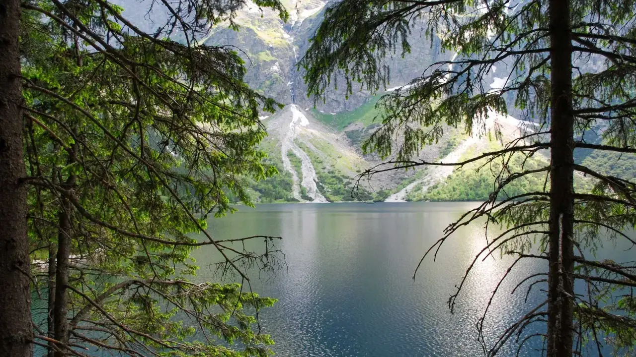 Morskie Oko, Tatry. Spokojna tafla jeziora odbija skaliste szczyty gór.