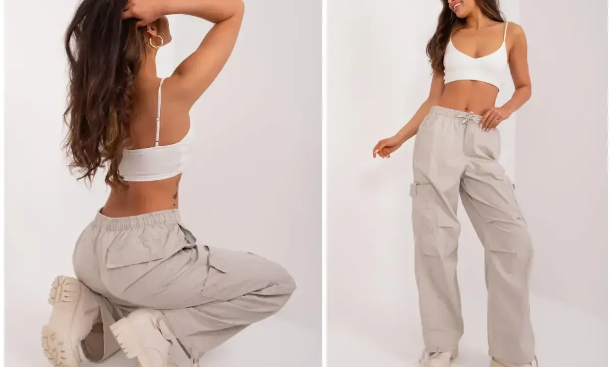 Modelka prezentuje luźne, beżowe spodnie cargo i biały top. Idealne pytanie: jakie buty do kulotów? Grube trapery świetnie uzupełniają ten look.