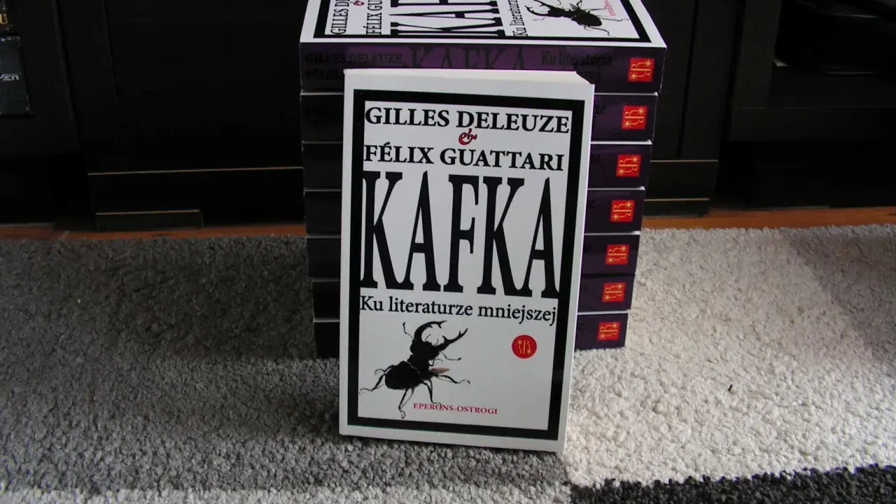 Stos książek z "Kafką" Deleuze'a i Guattariego, z widocznym żukiem na okładce, nawiązującym do prozy Franza Kafki.