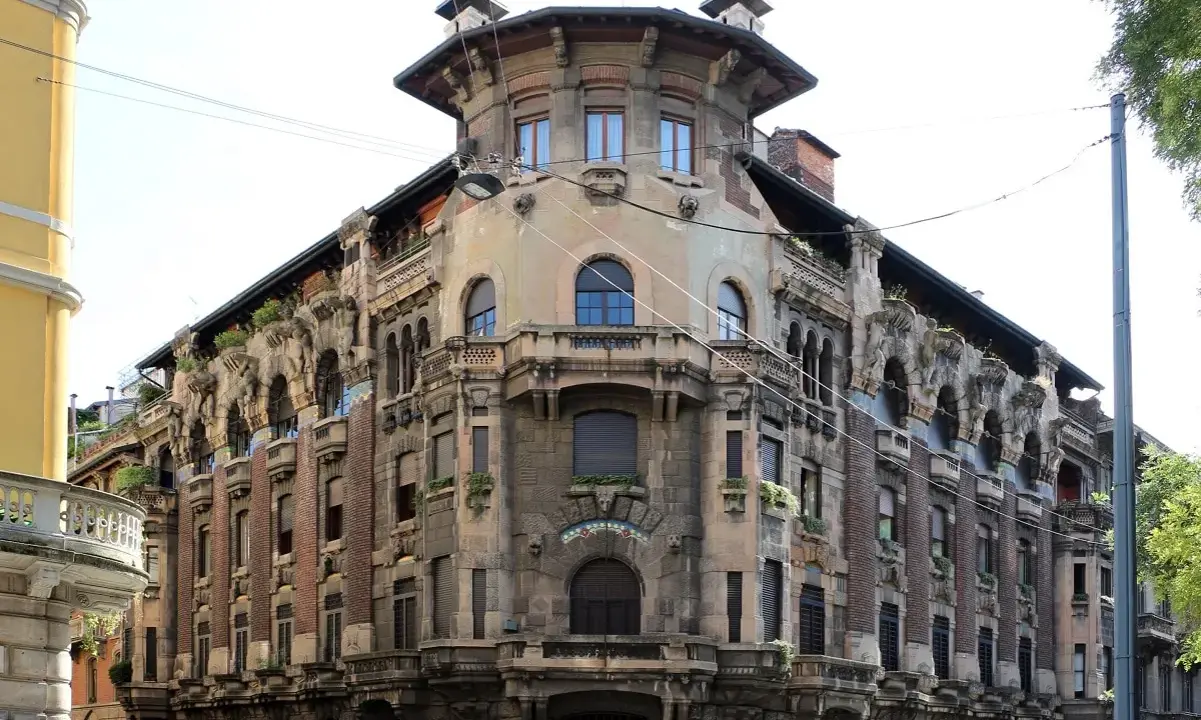 Dettagli architettonici unici del **Palazzo Galimberti Milano**, con balconi ornati e sculture che emergono dalla facciata.