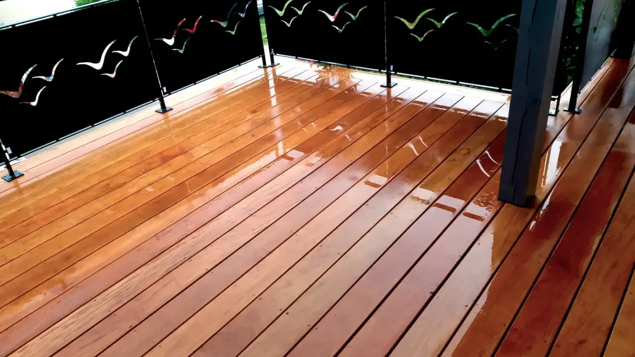 Terrasse privative en copropriété avec un plancher en bois brillant et des panneaux décorés de silhouettes d'oiseaux.