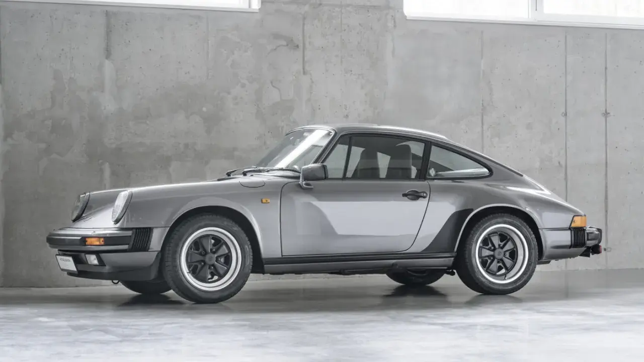 Grauer Porsche 911 G-Modell steht vor einer Betonwand.