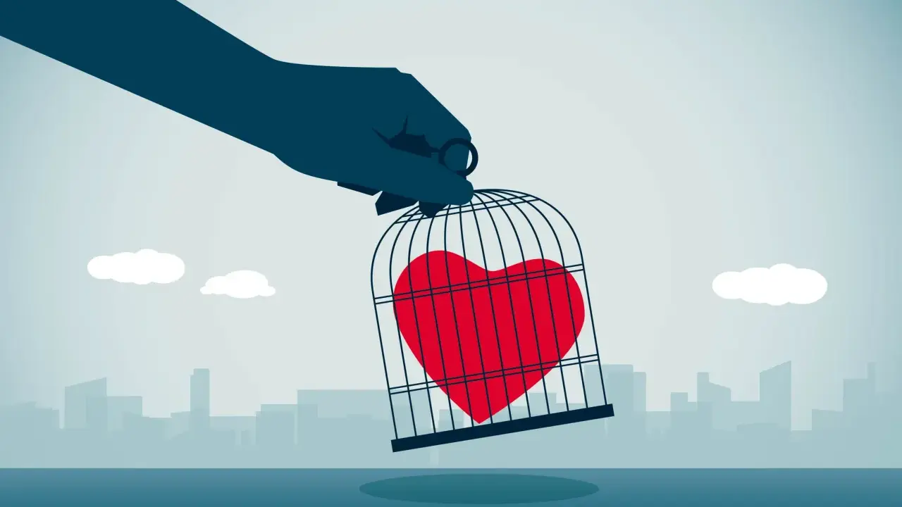 Mano che tiene una gabbia con un cuore rosso dentro, simbolo di esempi di manipolazione emotiva.
