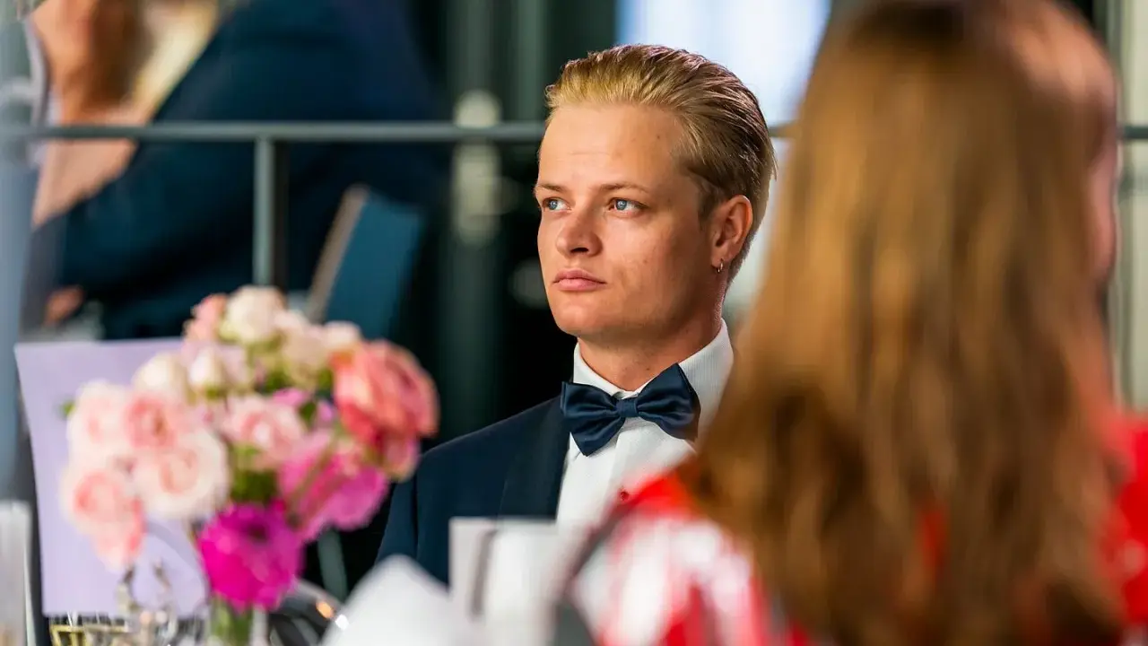 Marius Borg Høiby, klädd i smoking, sitter vid ett bord med blommor.