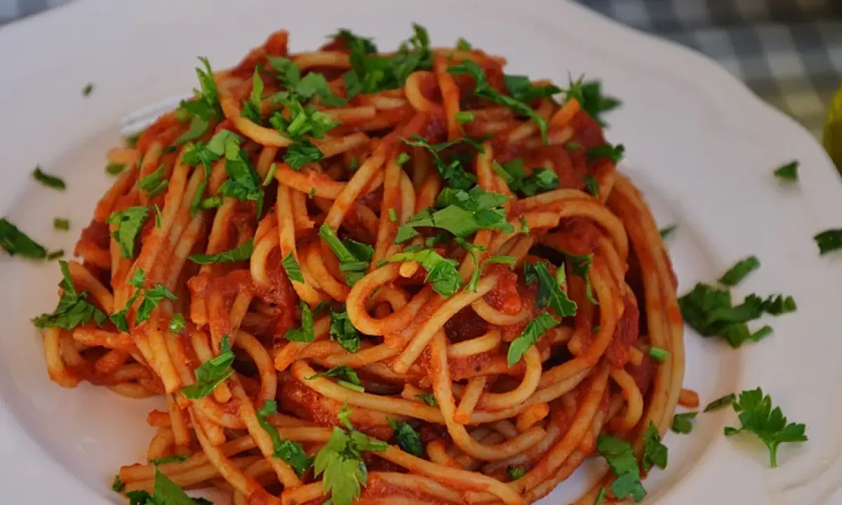 Pyszne spaghetti z sosem pomidorowym i natką pietruszki. Idealny przepis, jak zrobić spaghetti, by zachwycić domowników.