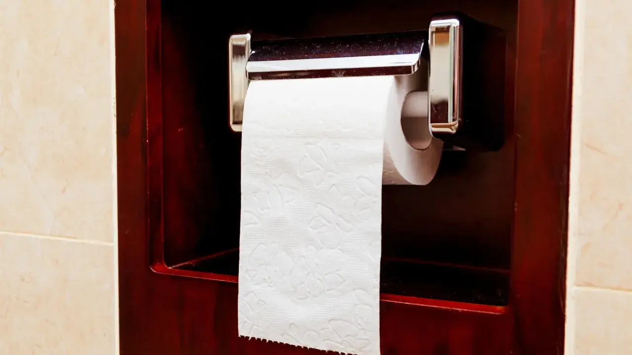 Uchwyt na papier toaletowy zamontowany jest na wygodnej wysokości, w ciemnej, drewnianej wnęce.
