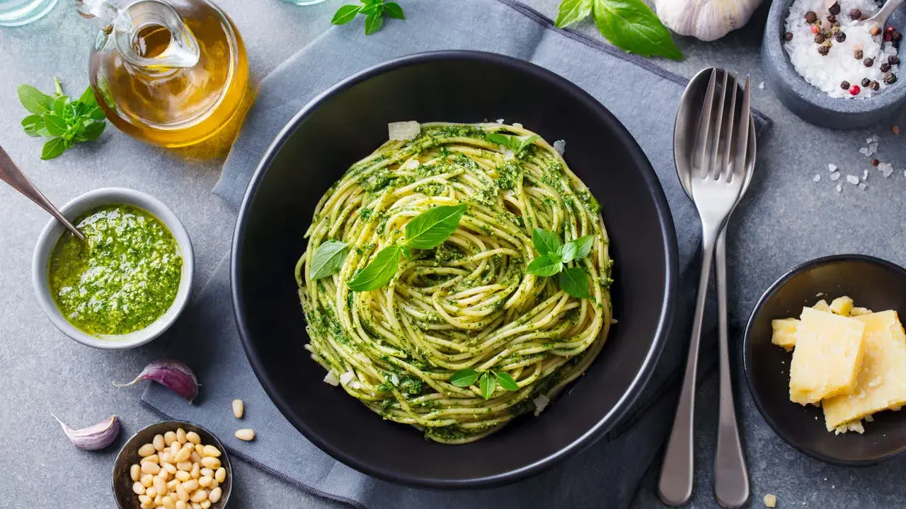 Pyszny obiad bez mięsa: spaghetti z pesto, świeżą bazylią, orzeszkami pinii i parmezanem.