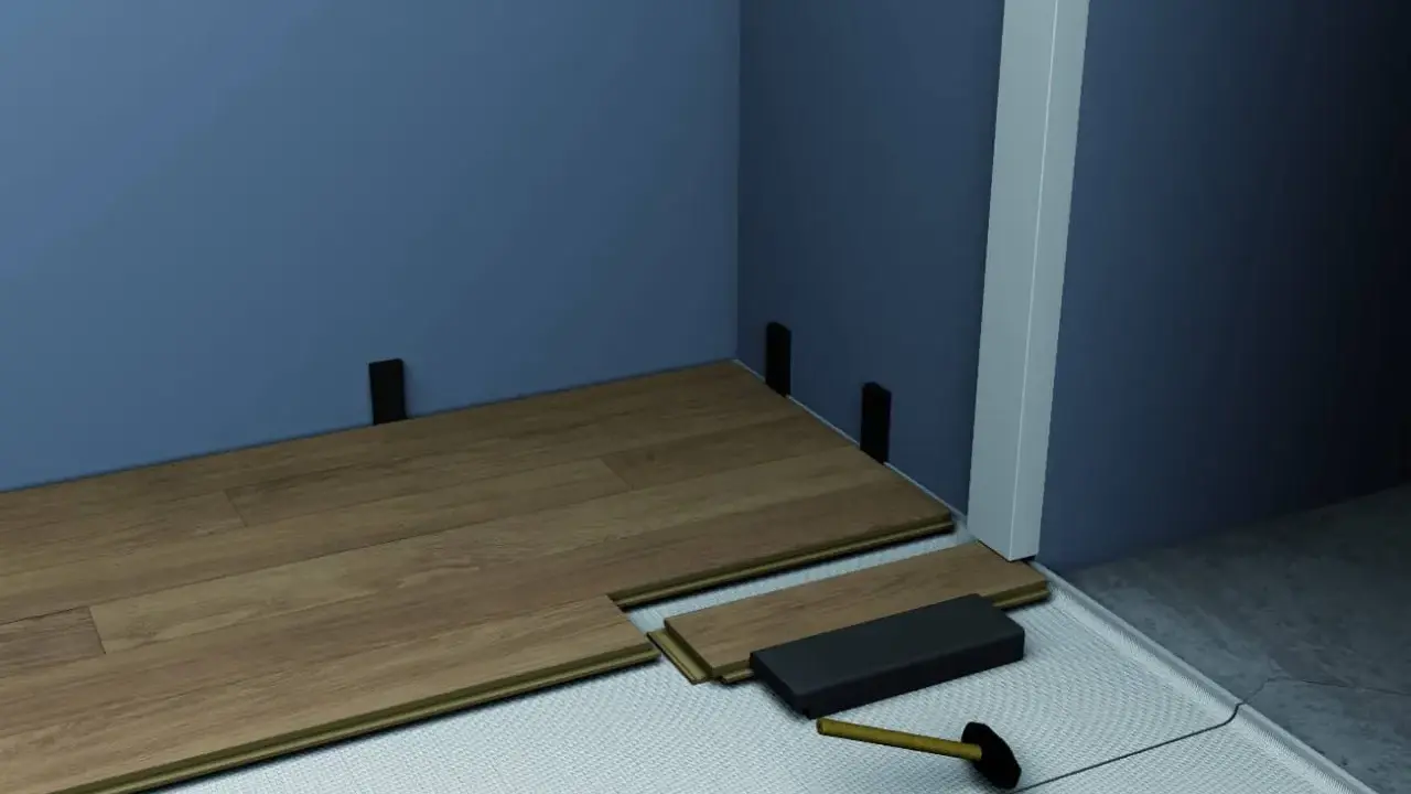 Instalación de suelo laminado. Se ven piezas de madera, un mazo y soportes para el rodapié que es la pieza final.