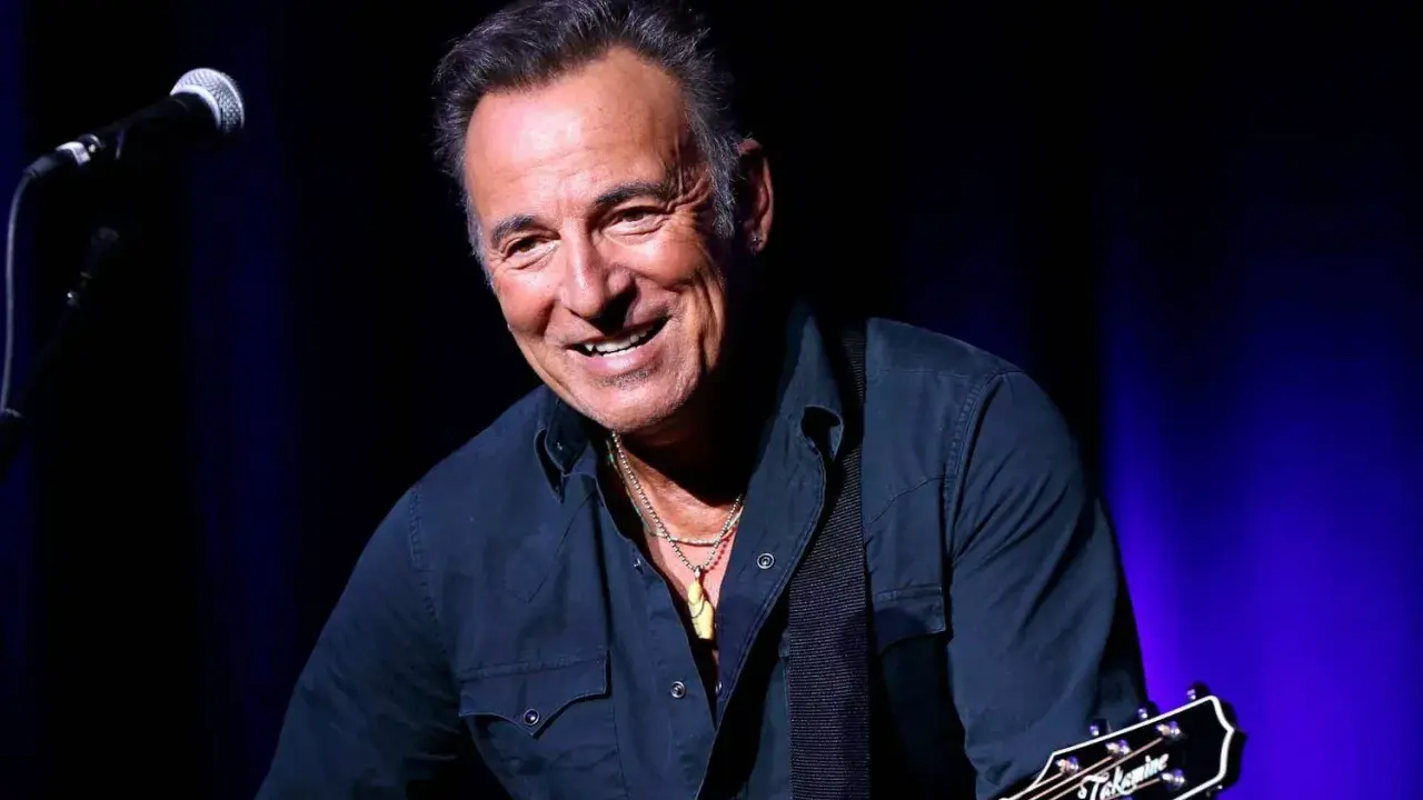 Bruce Springsteen ler glatt på scenen i Sverige, med gitarr och mikrofon redo för en oförglömlig kväll.