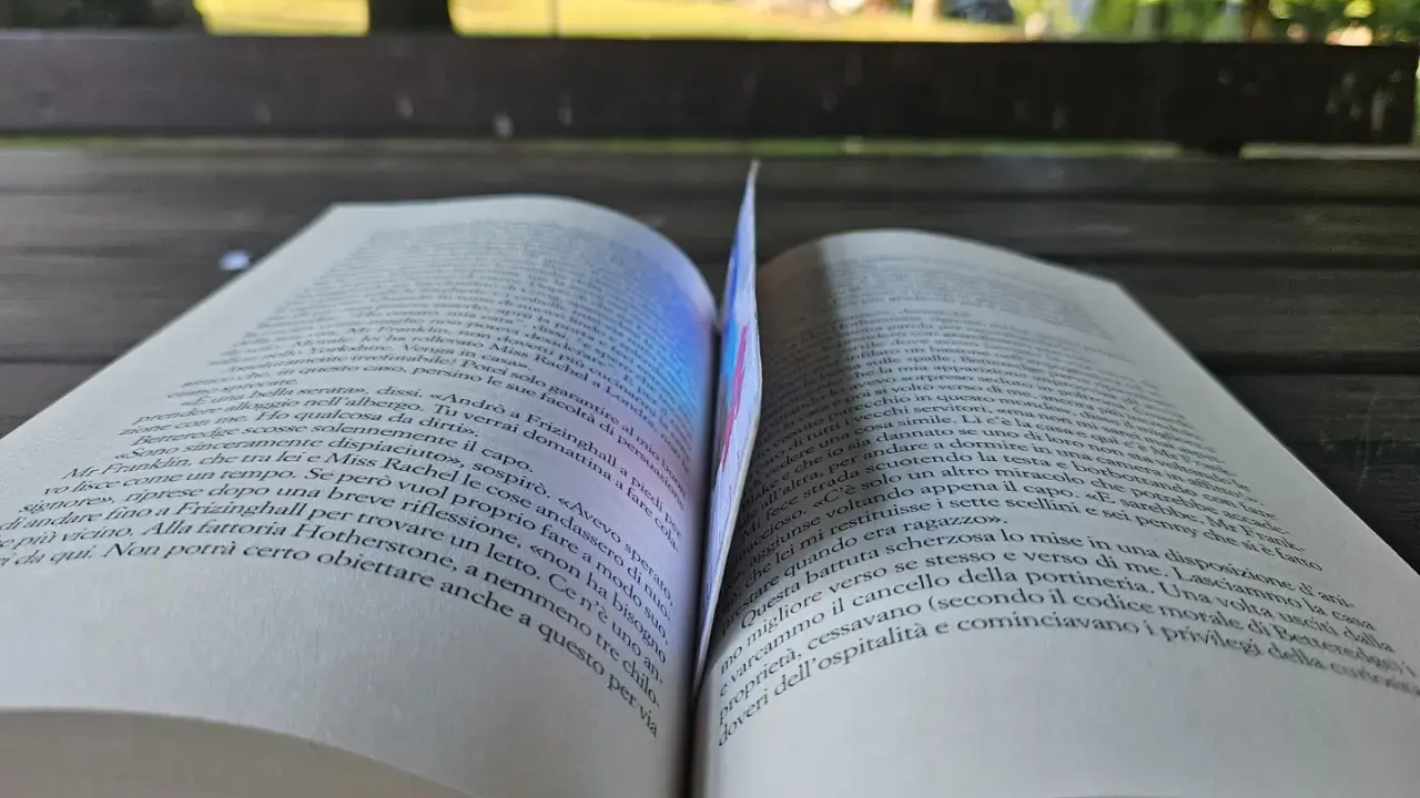 Un libro aperto, con pagine che sembrano sussurrare storie, forse della saga "50 sfumature".