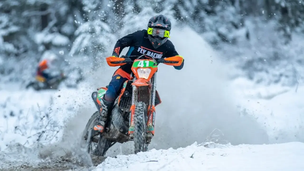 Motocyklista w akcji podczas wyścigu enduro w zimowej scenerii. To właśnie jest **enduro co to** za sport!