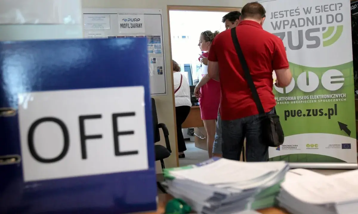 Na biurku leży segregator z napisem OFE. Ludzie stoją przy tablicy informacyjnej ZUS, pytając, czy można wypłacić pieniądze z OFE.