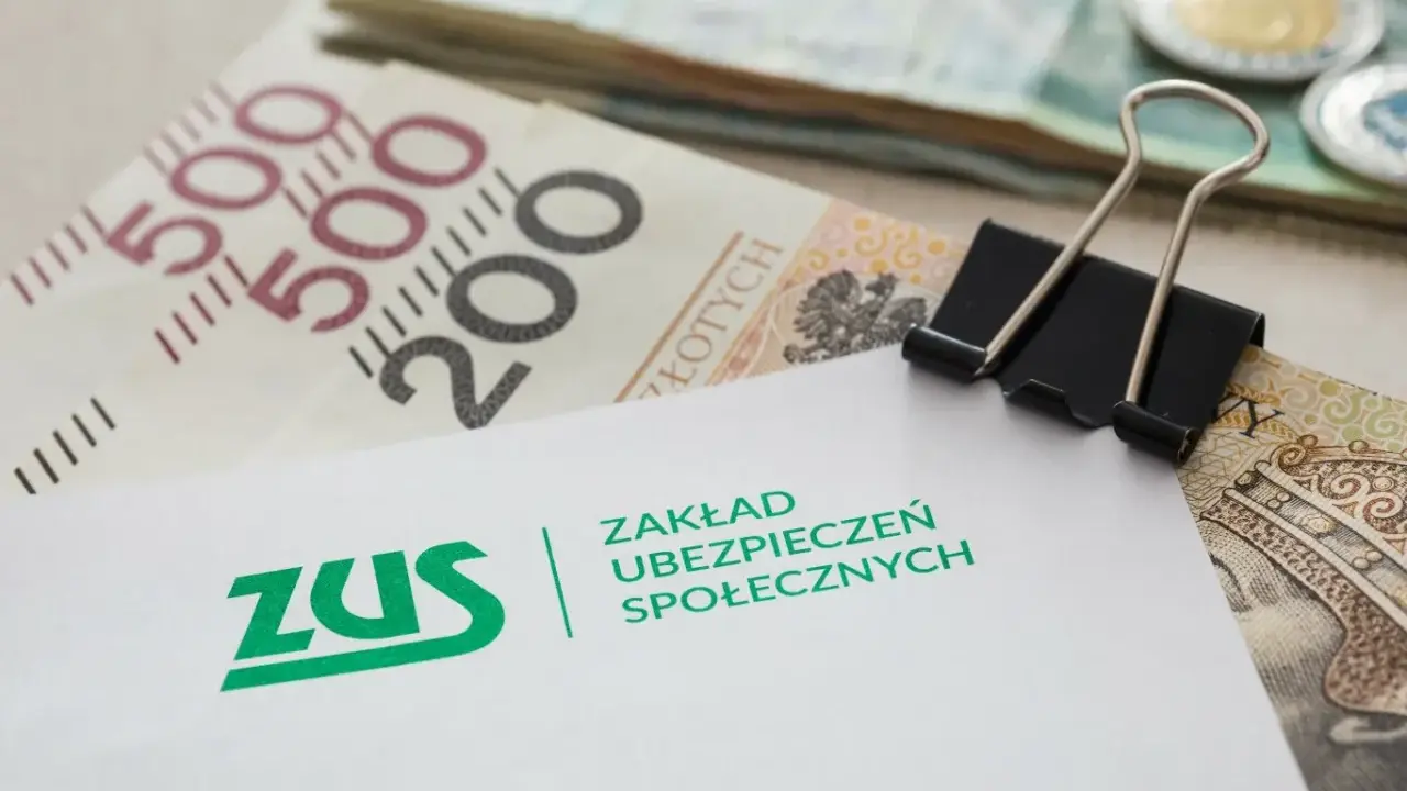 ZUS i polskie banknoty. Dokument z logo ZUS, symbolizujący potencjalne odszkodowanie z ZUS, leży na stosie pieniędzy.