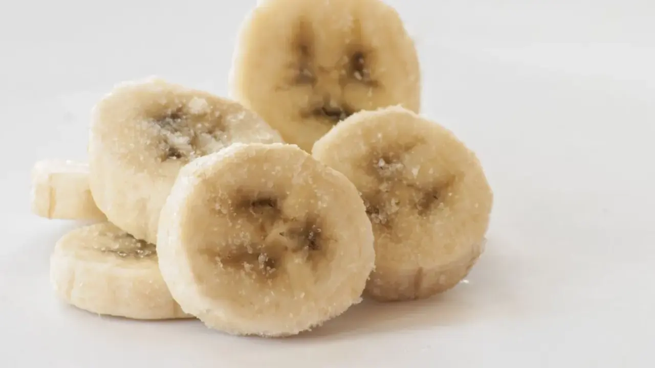 Ein Haufen gefrorener Bananenscheiben, bereit zum Einfrieren für Smoothies oder Desserts.