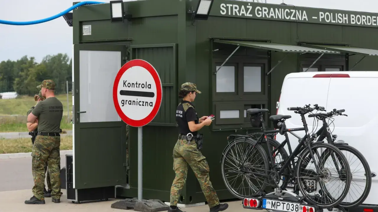 Strażnicy graniczni prowadzą kontrole na granicy niemieckiej. Obok zielonego punktu kontrolnego stoją dwa rowery na bagażniku samochodu.