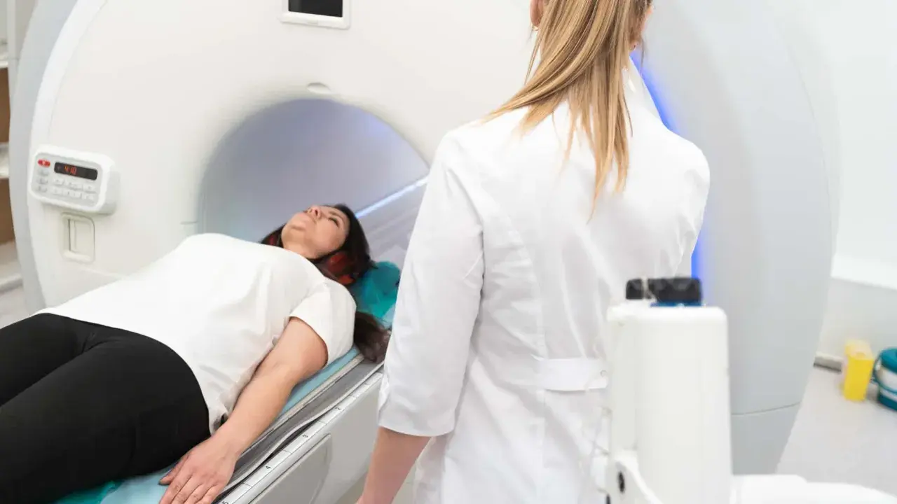 Patient liegt auf dem Tisch für die pelottierung des duralschlauches. Eine Ärztin in weißem Kittel überwacht den Vorgang.