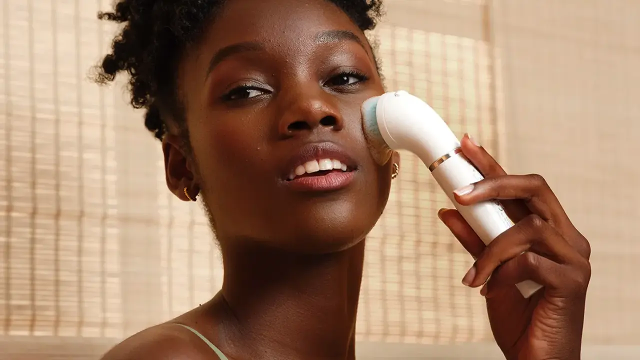 Donna con spazzola elettrica per esfoliazione viso, per una pelle luminosa e pulita.