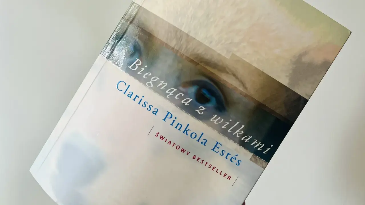 Książka "Biegnąca z wilkami" Clarissy Pinkoli Estés, światowy bestseller, z fragmentem oka na okładce.