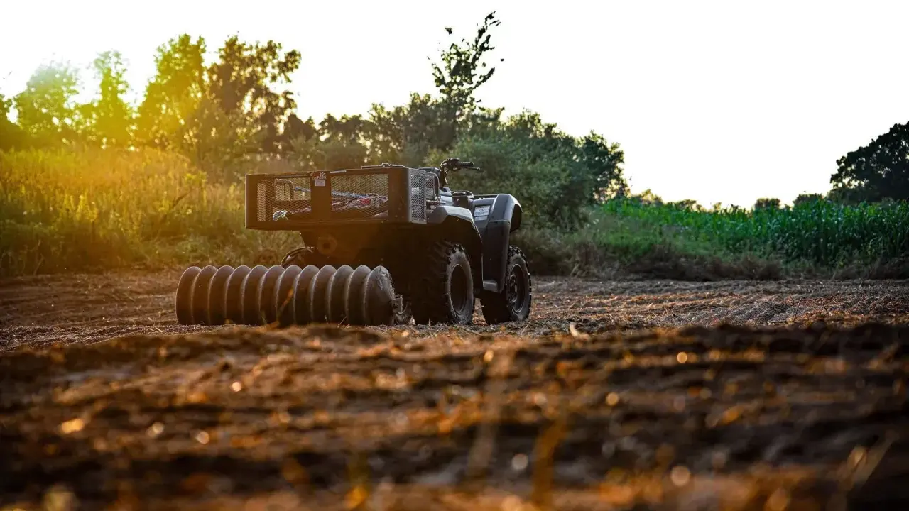 ATV with a roller attachment, ready for field work. This is one of many tractor attachments that can help prepare the soil.
