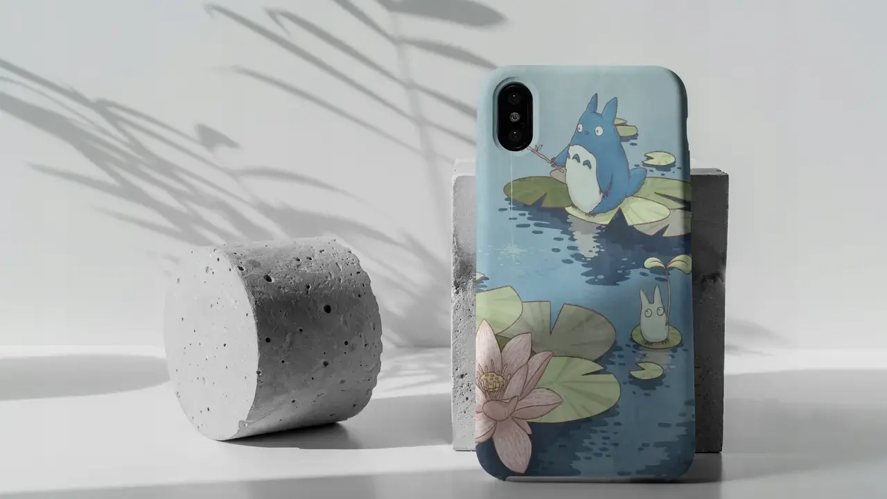 Urocze etui na Pixel 7 z Totoro łowiącym ryby na tle stawu z liliami wodnymi.