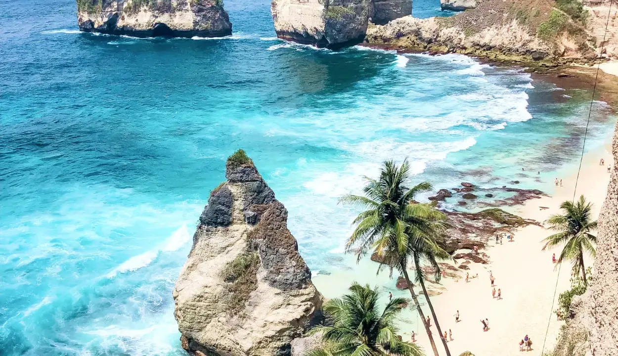 Rajska plaża z palmami i turkusową wodą. Zastanawiasz się, ile się leci na Bali, by zobaczyć taki widok?