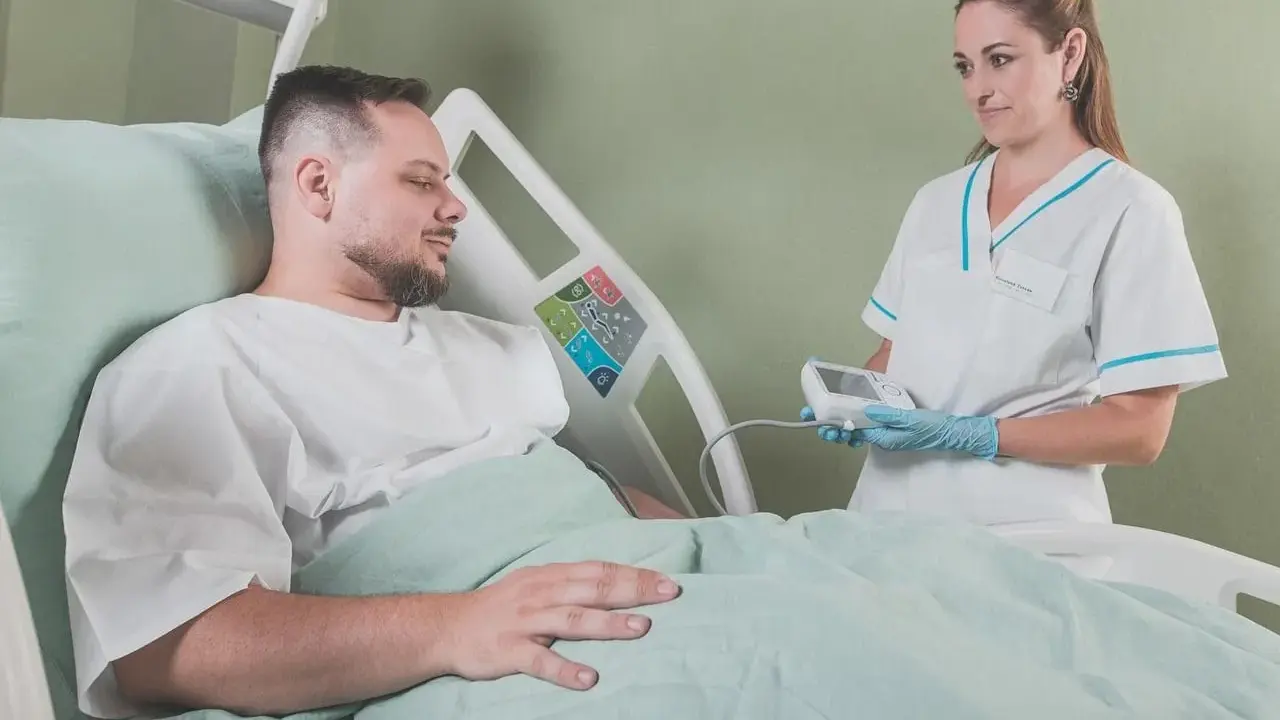 Pielęgniarka bada pacjenta w szpitalu. Walka z rakiem i nowotworem wymaga wsparcia medycznego.