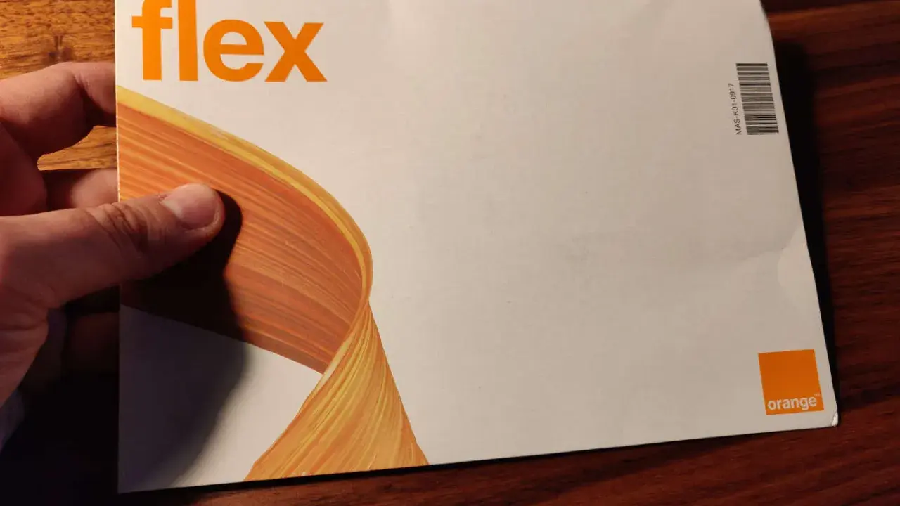 Dłoń trzyma kopertę z napisem "flex" i logo Orange. To oferta Orange Flex.