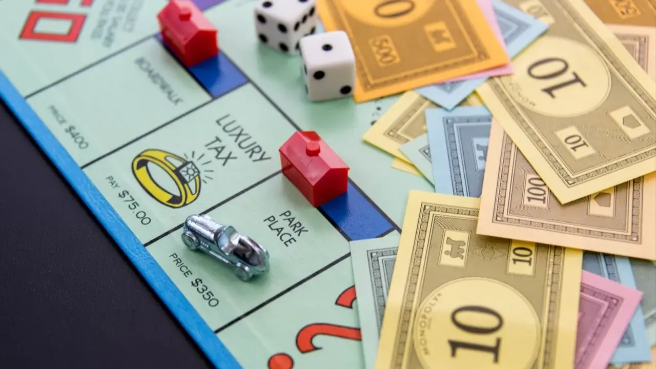 Na planszy Monopoly leżą pionki, kostki i banknoty. Czas na wielką rozgrywkę, ale gramy!