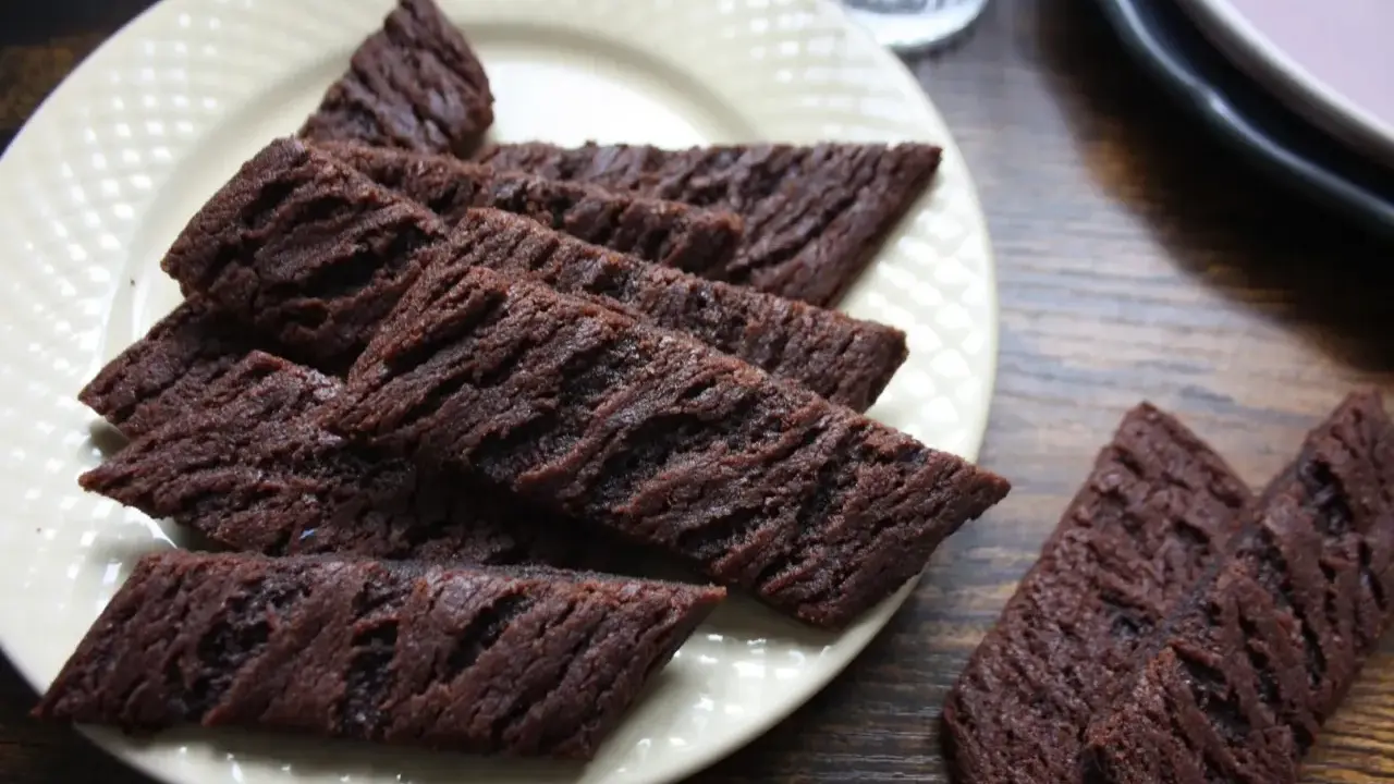 Chokladsnittar recept: Mörka, avlånga chokladkakor med räfflad yta ligger på en ljusgul tallrik. Perfekta till fikat!