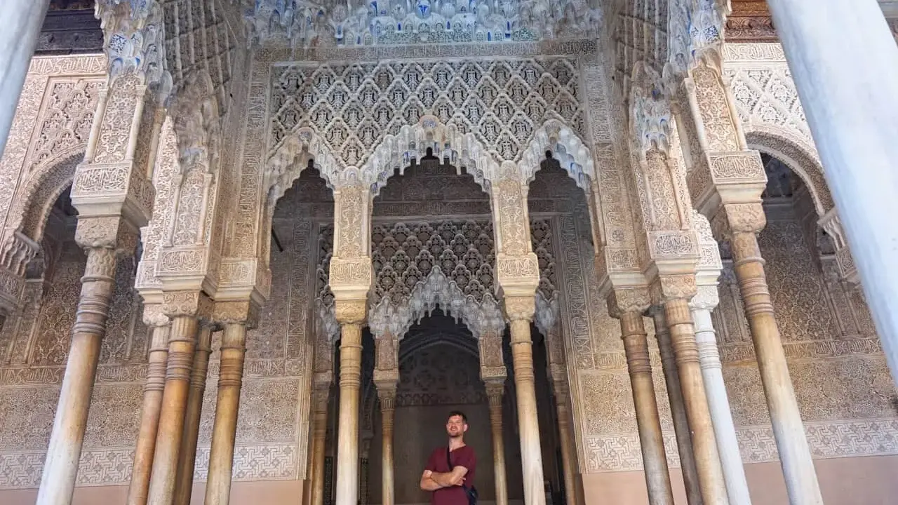 Mann vor kunstvoll verzierter Säulenhalle der Alhambra. Gute alhambra tickets kaufen erfahrungen sind Gold wert!
